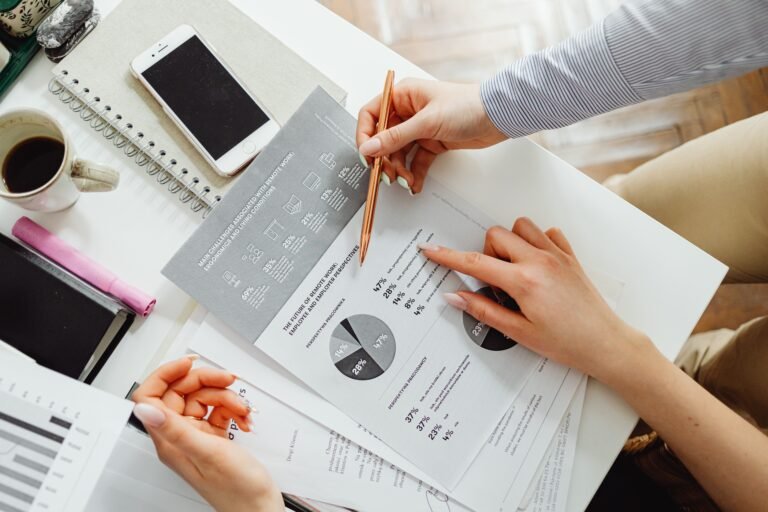 Documentos financieros con gráficos y cifras revisados por un equipo